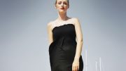 Kvinde foran lystbådhavn iklædt sort maxikjole